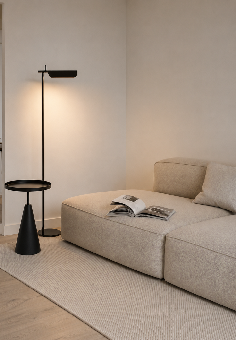 Cream modular chaise with black side table and floor lamp, warm minimalist living space
